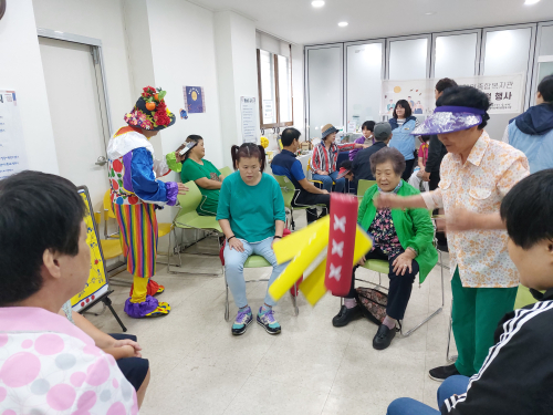 남부센터 추석 명절 행사 사진(이용자들이 한데 모여 윷놀이를 진행하고 있는 모습)