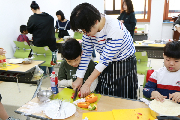 엄마가 자녀의 재료 다듬기를 도와주는 모습