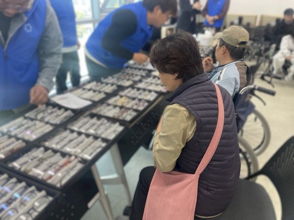 눈건강시력지킴이사업에 참여한 장애가족이 맞춤 안경을 제작하기 위한 안경테를 고르고 있습니다.