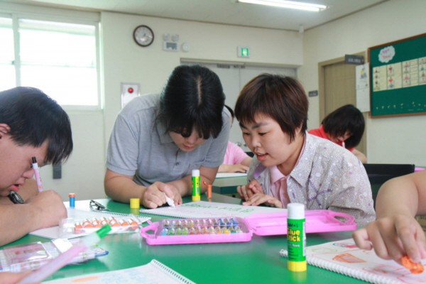 자원봉사자와 함께 플랜카드를 만드는 사진입니다.